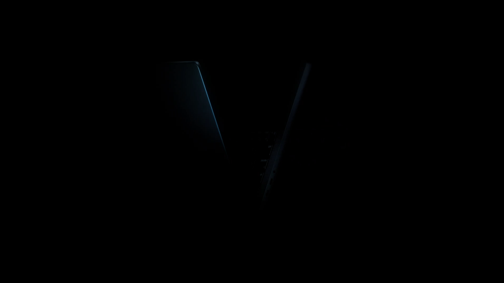 A V-shaped view of a MacBook Pro, with blue light pulsing from top left to top right.